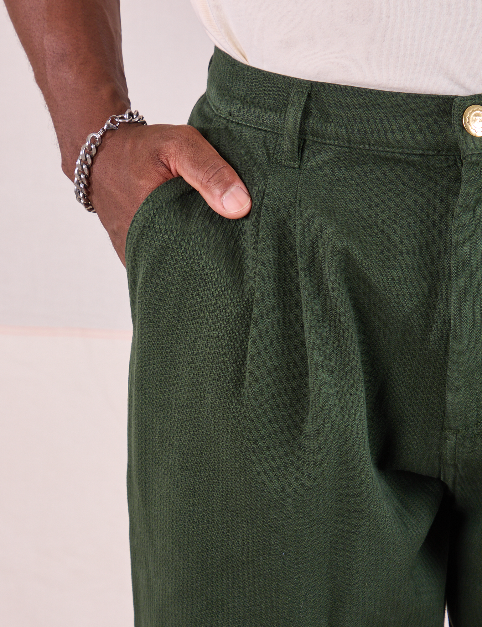 Heritage Trousers in Swamp Green front pocket close up. Issac has his hand in the pocket.