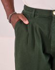 Heritage Trousers in Swamp Green front pocket close up. Issac has his hand in the pocket.