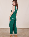 Angled back view of Original Overalls in Mono Hunter Green worn by Hana