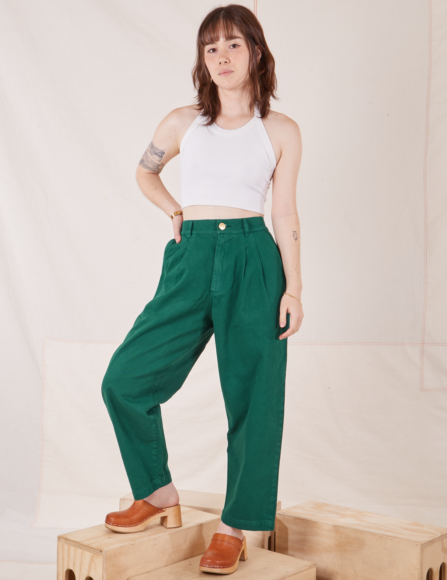 Hana is 5&#39;3&quot; and wearing XXS Petite Heavyweight Trousers in Hunter Green paired with Halter Top in vintage tee off-white