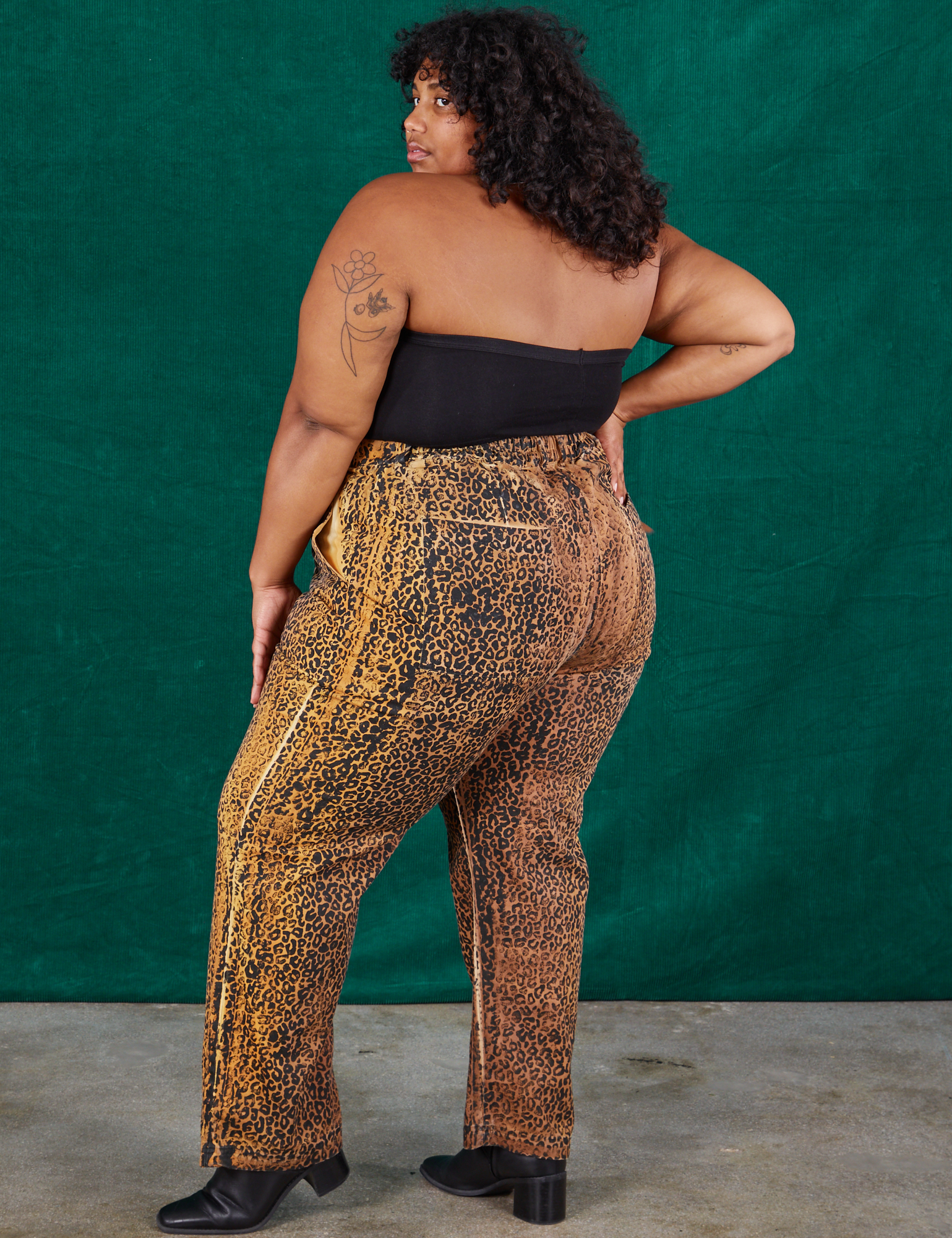 Angled back view of Leopard Work Pants and black Halter Top on Morgan