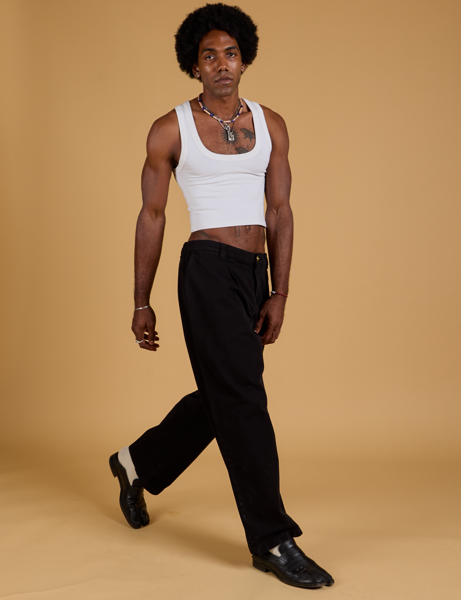Angled front view of Baggy Mid-Rise Trousers in Basic Black and vintage tee white Cropped Tank