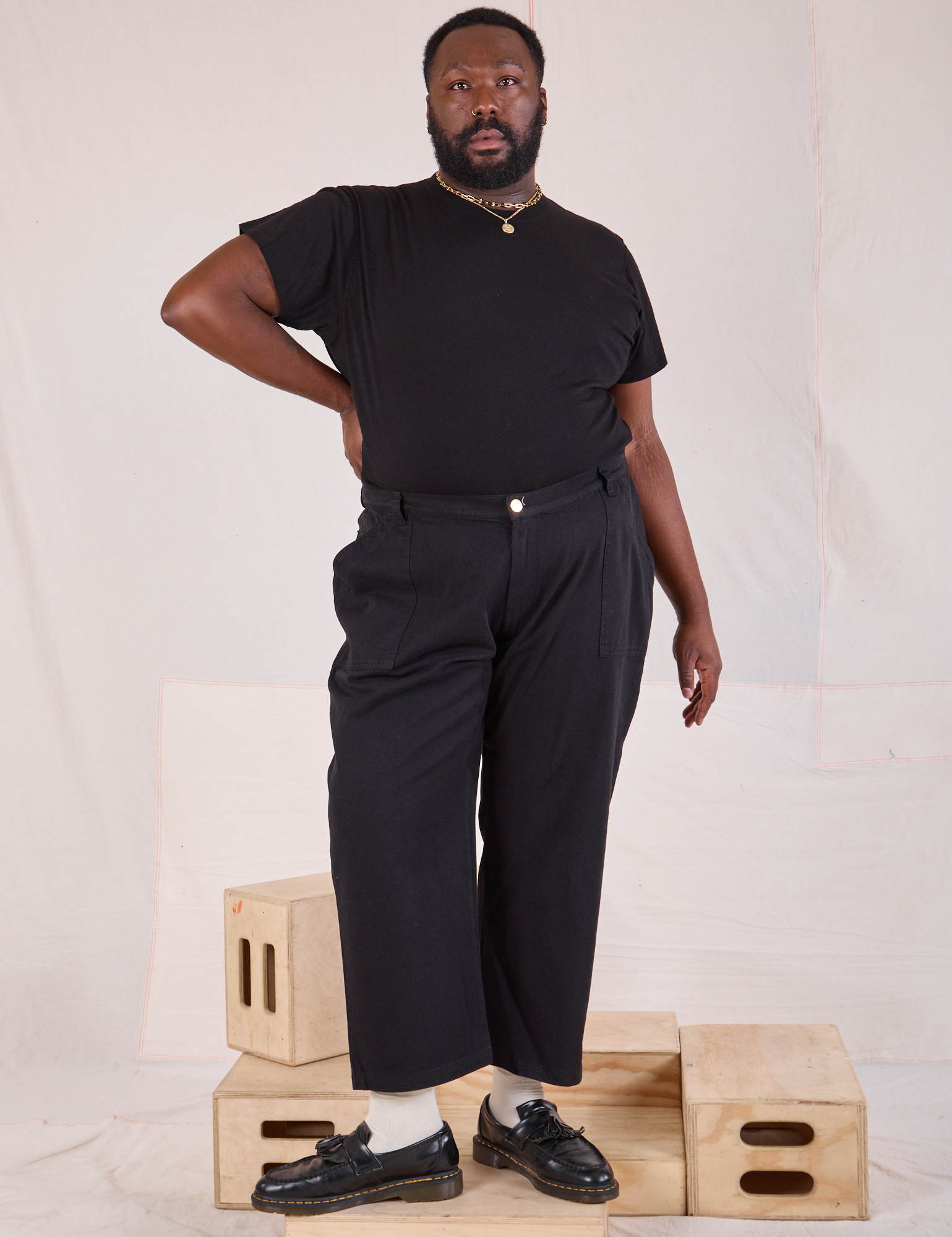 Elijah is 6'3" and wearing 1XL Mid-Rise Work Pants in Basic Black and black Organic Vintage Tee