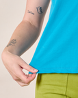 Mismatched Tee in Blue & Green bottom hem close up on Alex