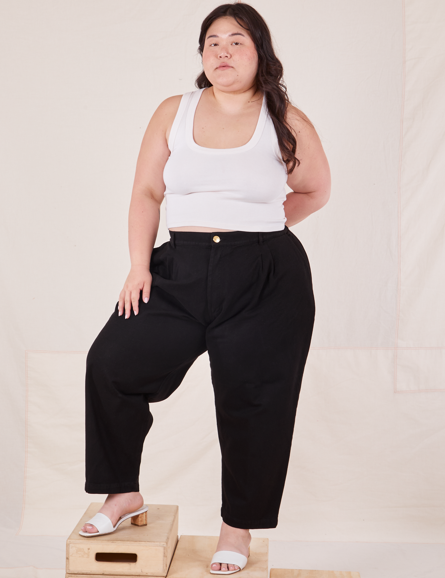 Ashley is 5&#39;7&quot; and wearing 1XL Petite Organic Trousers in Basic Black paired with Cropped Tank Top in vintage tee off-white