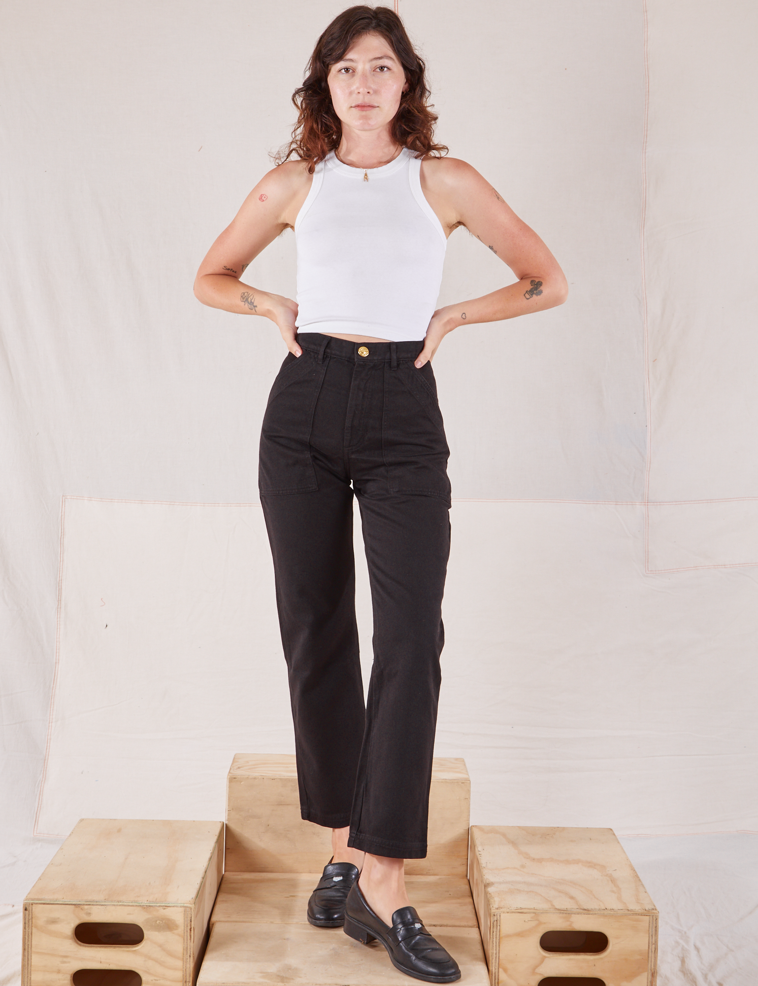 Alex is 5'8" and wearing XXS Organic Work Pants in Basic Black paired with a Racerback Tank in vintage tee off-white