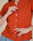 Front close up of Pantry Button-Up in Chili Red with white buttons on Alex