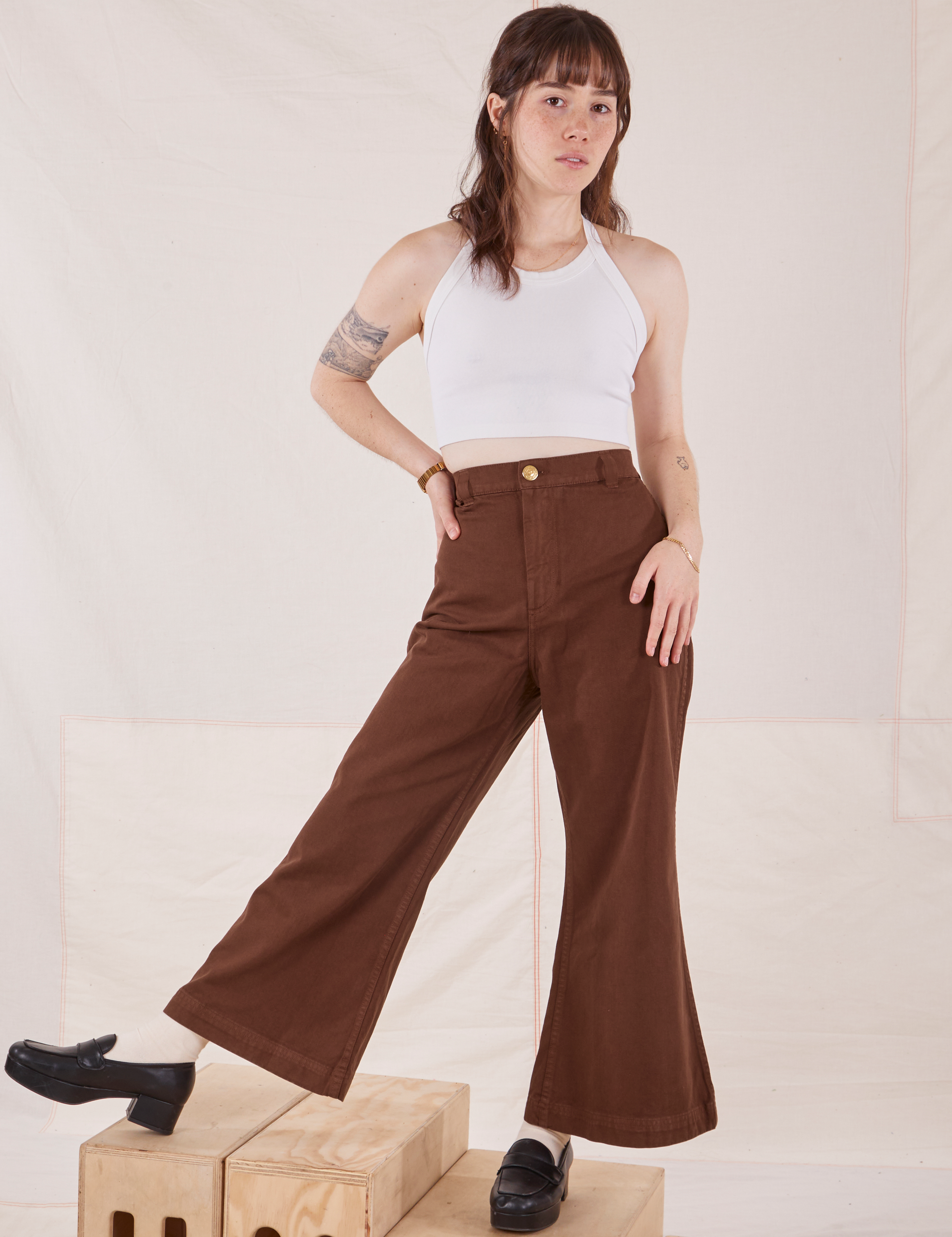 Hana is 5&#39;3&quot; and wearing P Petite Bell Bottoms in Fudgesicle Brown paired with a Halter Top in vintage tee off-white