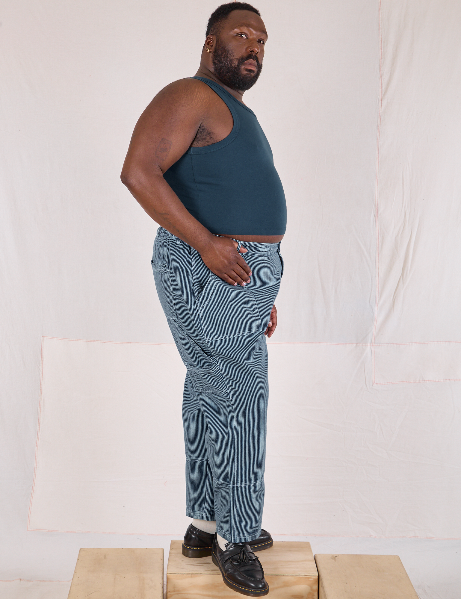 Side view of Railroad Carpenter Jeans in Baby Blue and marine blue Muscle Tee on Elijah
