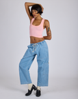 Kira is wearing Cropped Tank Top in Baby Pink and light wash Denim Drop Pocket Pants