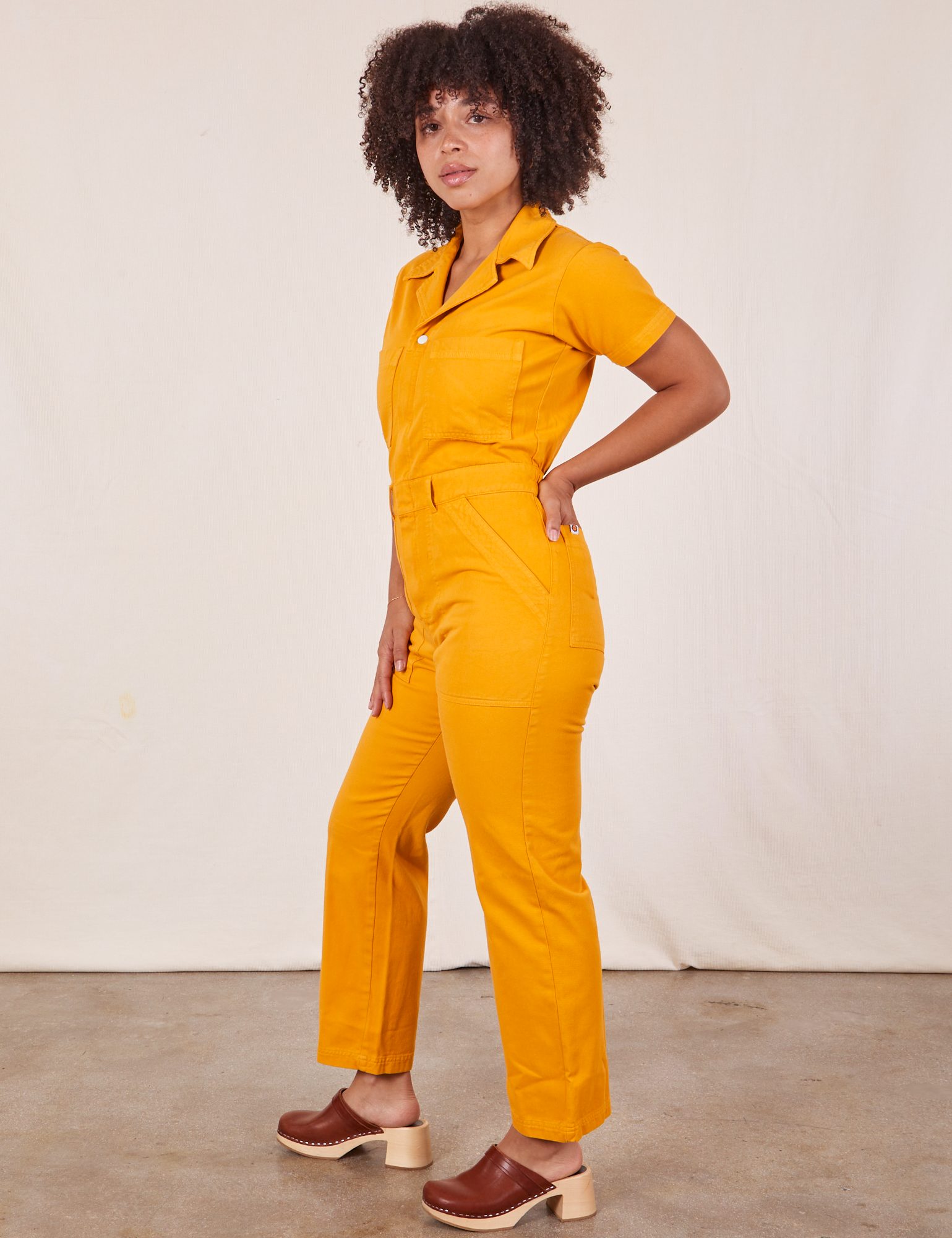 Side view of Short Sleeve Jumpsuit in Mustard Yellow worn by Gabi
