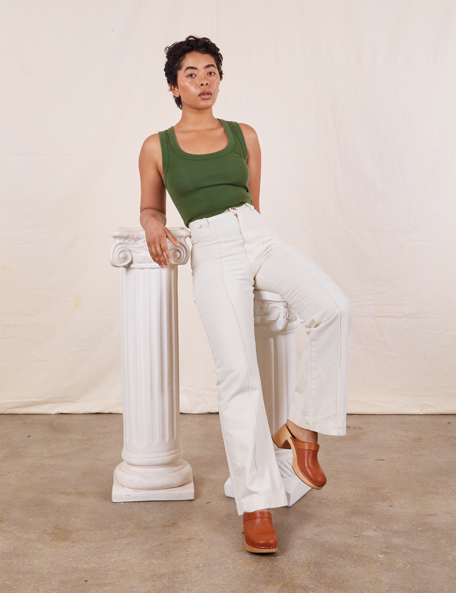 Mika is wearing Tank Top in Dark Emerald Green and vintage off-white Western Pants
