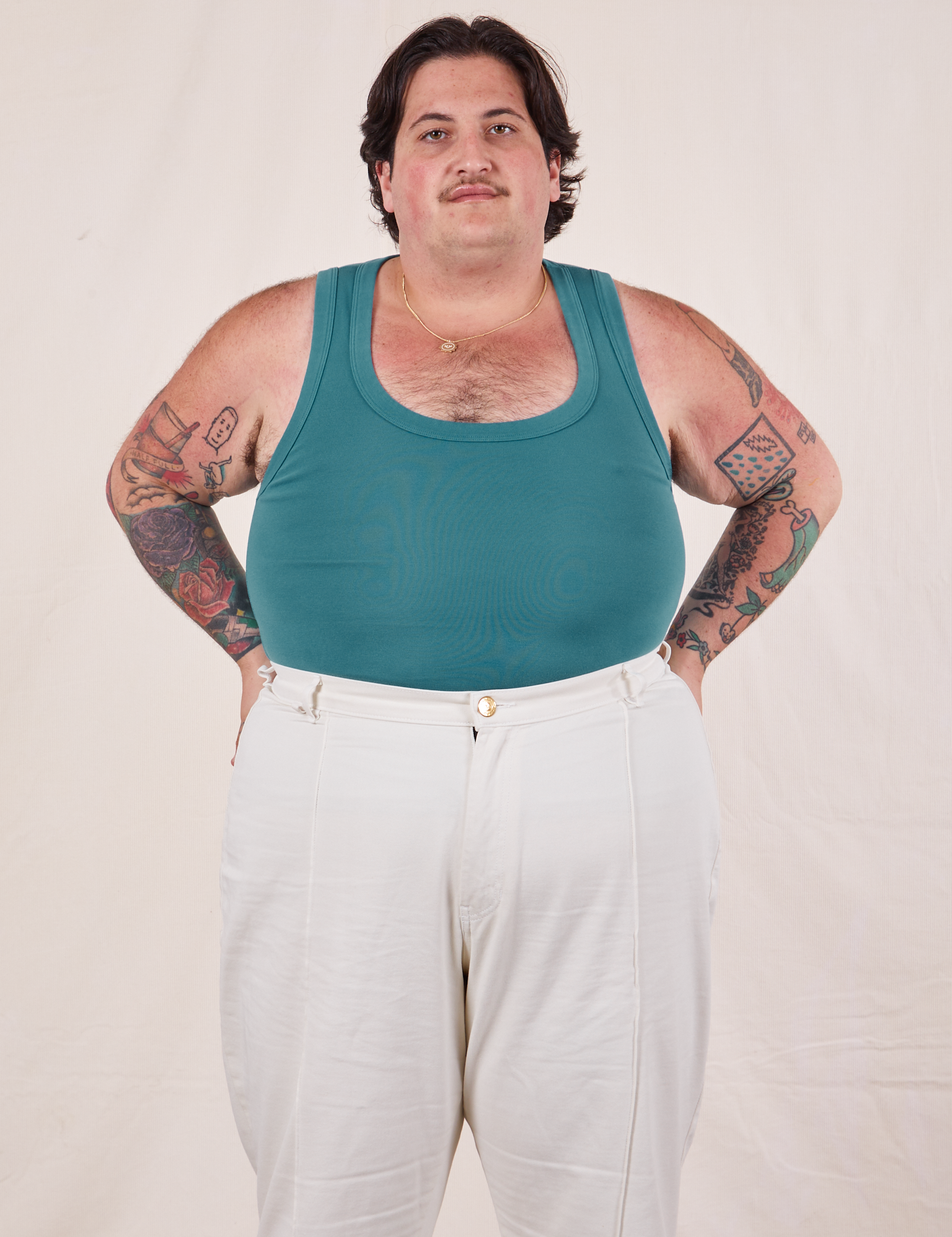 Sam is wearing size XL Tank Top in Marine Blue paired with vintage tee off-white Western Pants