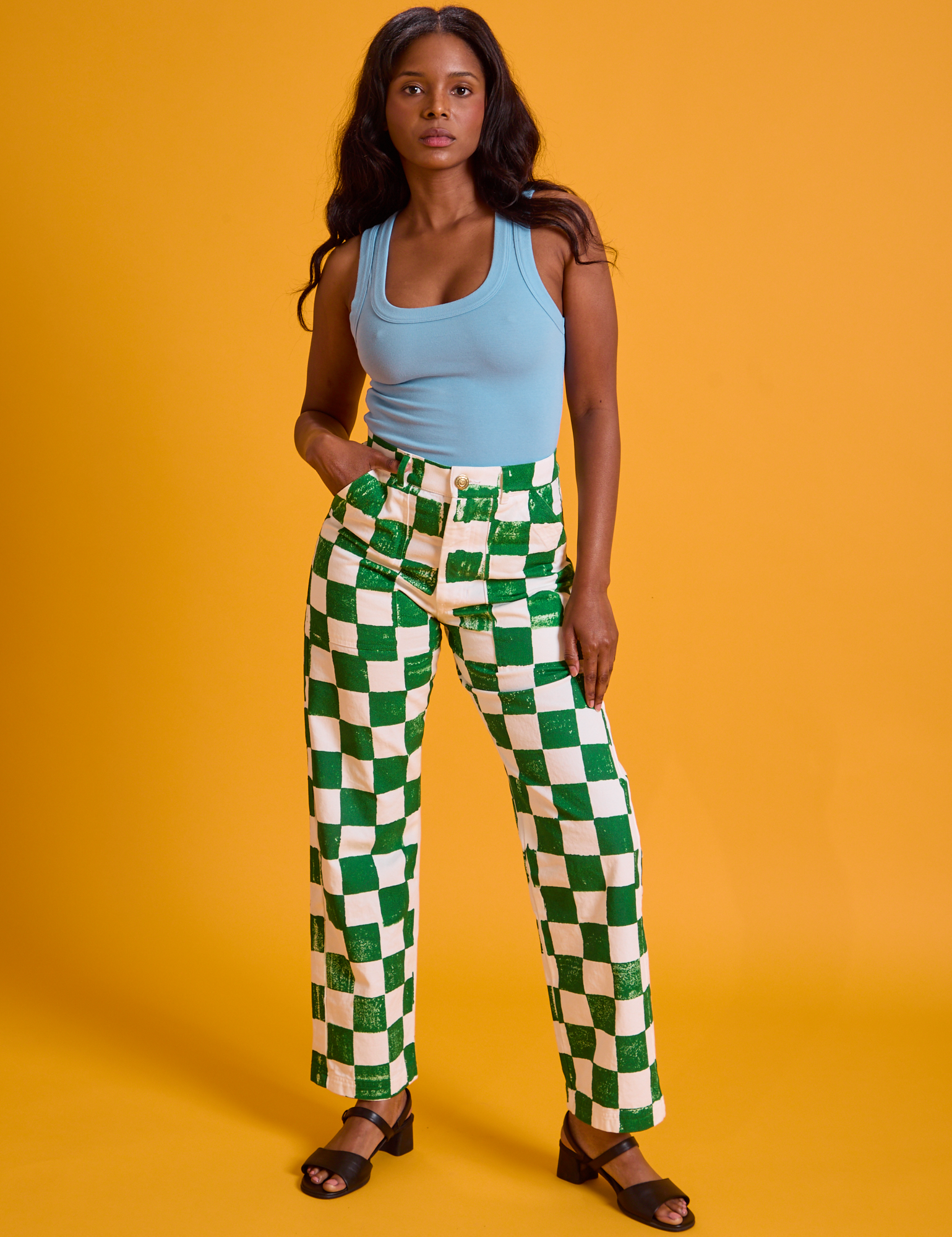 Kandia is 5'3" and wearing XS  Checkerboard Work Pants in White/Green paired with a baby blue Tank Top