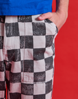 Close up of Quinn's hand in the front pocket of Checkerboard Work Pants in Black/White