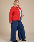 Side view of Denim Work Jacket in Mustang Red and dark wash Indigo Wide Leg Trousers on Juliet