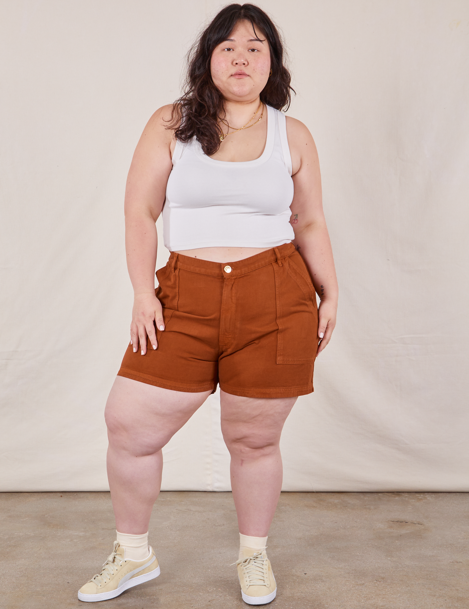 Ashley is 5’7” and wearing 1XL Classic Work Shorts in Burnt Terracotta paired with Cropped Tank Top in vintage tee off-white