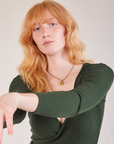 Margaret is wearing Wrap Top in Swamp Green
