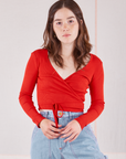 Hana is 5'3" and wearing size 1 Wrap Top in Mustang Red