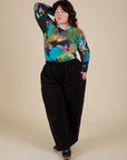 Ashley is wearing Long Sleeve Baby Tee in Rainbow Magic Waters paired with black Drop Pocket Cargo Pants