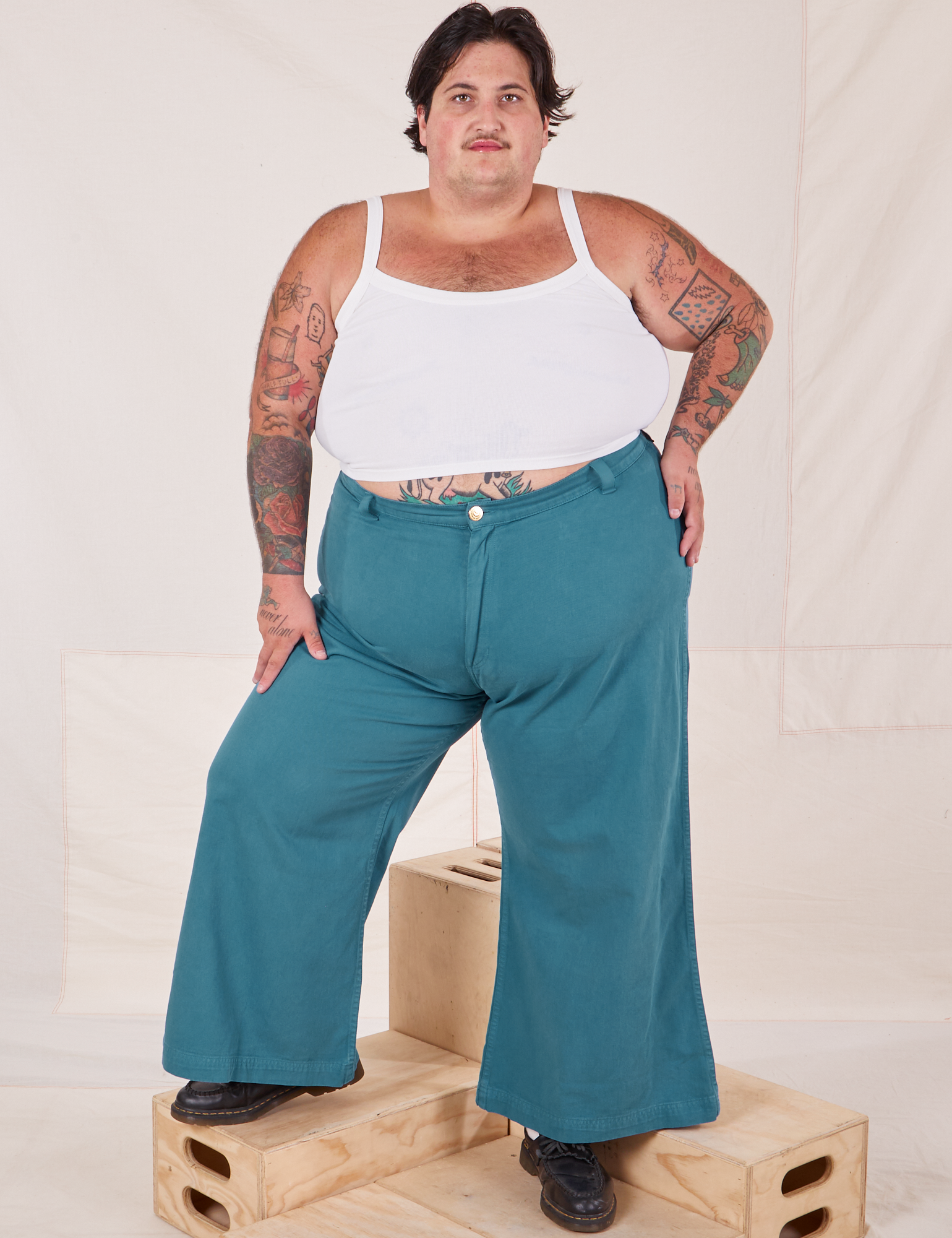 Sam is 5&#39;10&quot; and wearing 3XL and wearing Bell Bottoms in Marine Blue paired with vintage off-white Cami