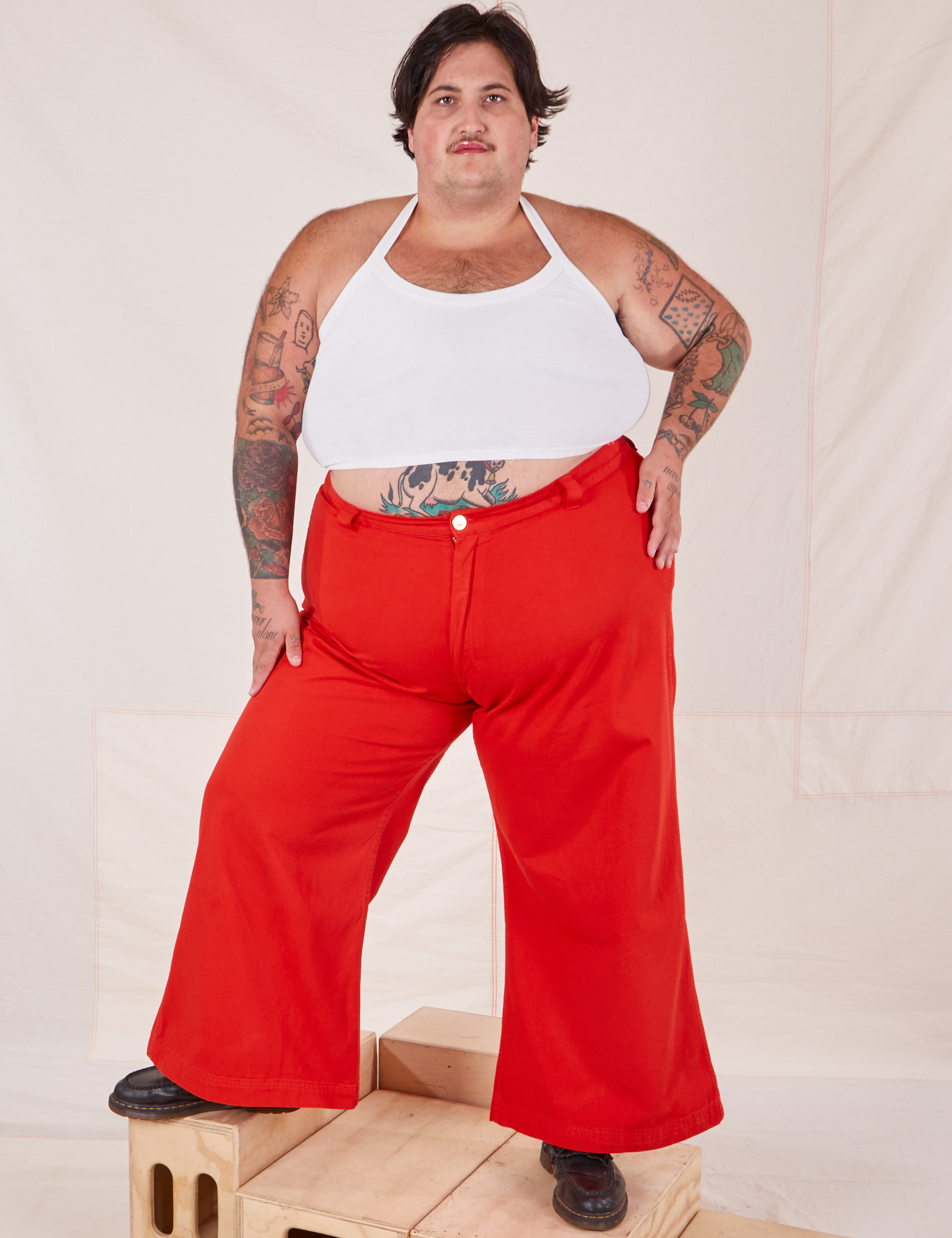 Sam is 5&#39;10&quot; and wearing 3XL Bell Bottoms in Mustang Red paired with Halter Top in vintage tee off-white