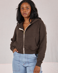 Kandia is wearing a zipped up Cropped Zip Hoodie in Espresso Brown and light wash Carpenter Jeans