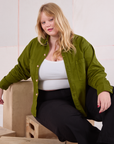 Juliet is wearing Cropped Overshirt in Summer Olive and basic black Bell Bottoms