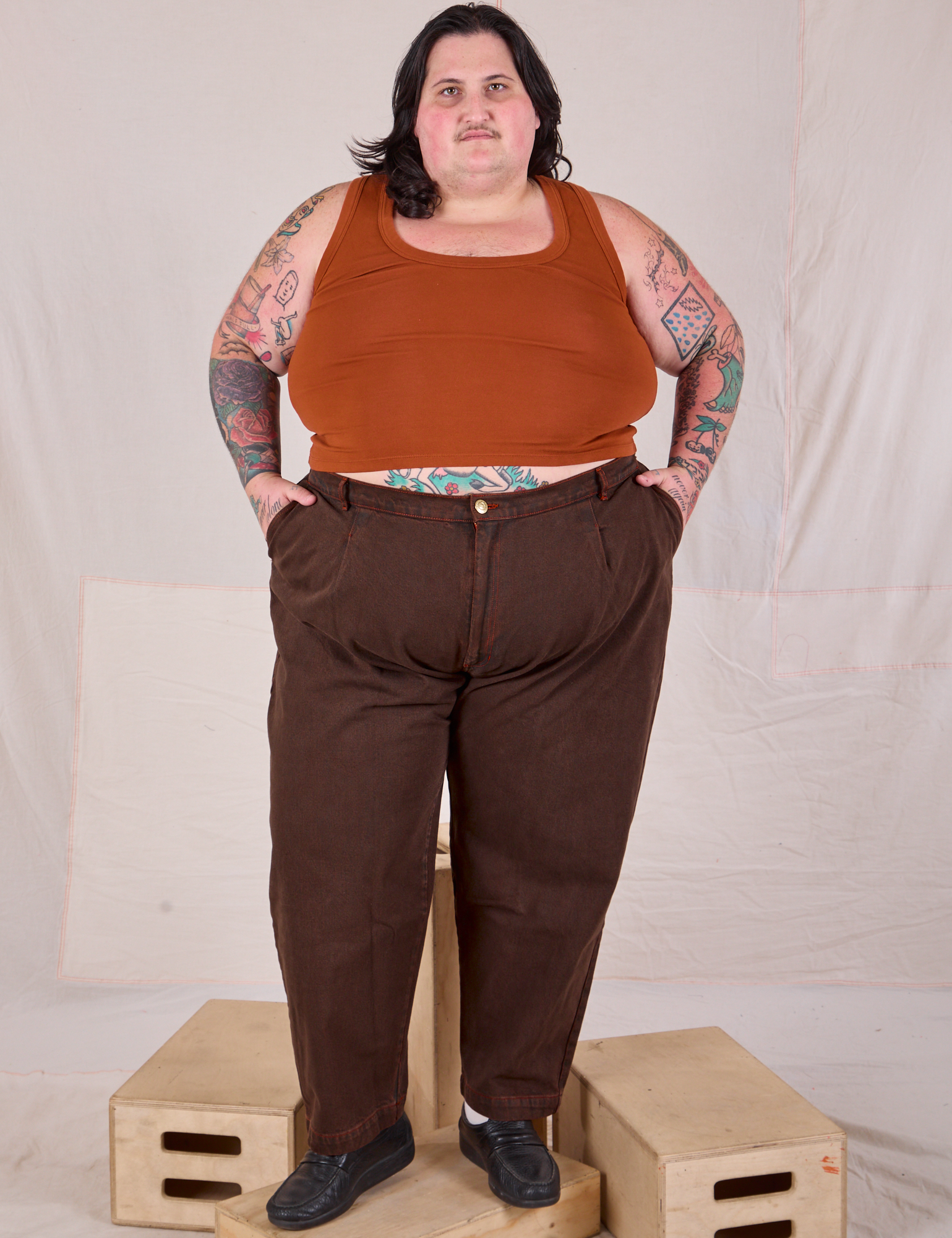 Sam is 5’10” and wearing 4XL Overdyed Denim Trouser in Fudge paired with a Cropped Tank in Burnt Terracotta