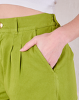 Close up of Alex's hand in the pocket of Heavyweight Trousers in Gross Green