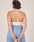 Back view of Halter Top in Vintage Off-White and light wash Sailor Jeans worn by Tiara