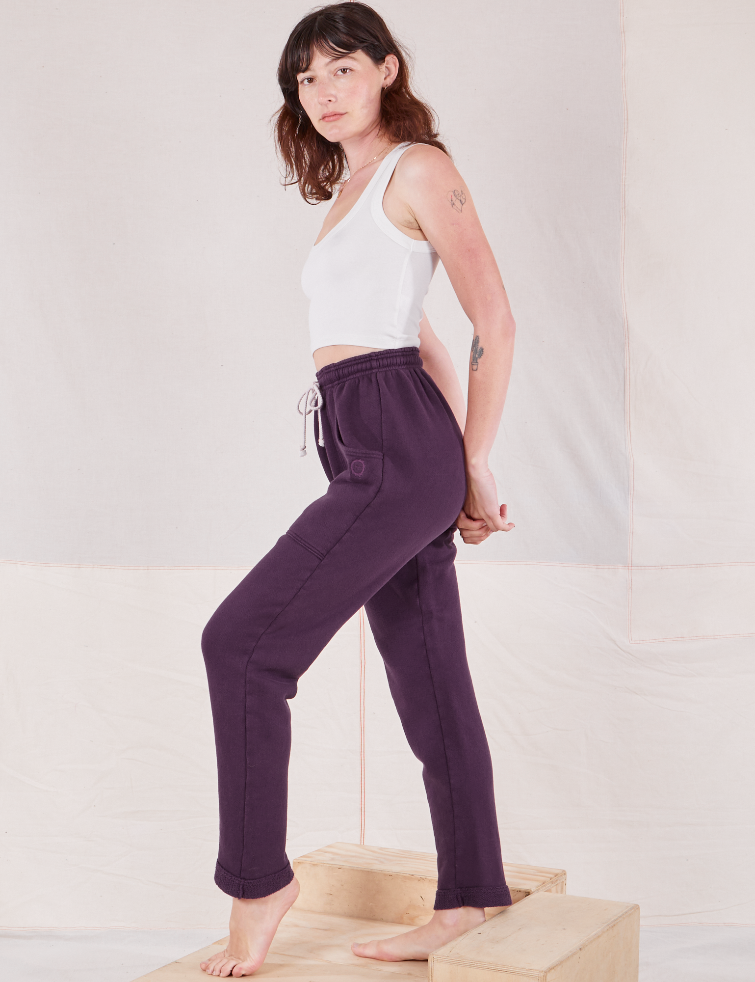 Side view of Rolled Cuff Sweat Pants in Nebula Purple and Cropped Tank in vintage tee off-white on Alex