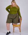 Juliet is wearing Pleated Trouser Shorts in Surplus Green and Long Sleeve Baby Tee in Summer Olive