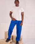Issac 5’10” is and wearing M Heritage Trousers in Royal Blue paired with an Organic Vintage Tee in vintage tee off-white