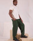 Side view of Heritage Trousers in Swamp Green and Organic Vintage Tee in vintage tee off-white on Issac