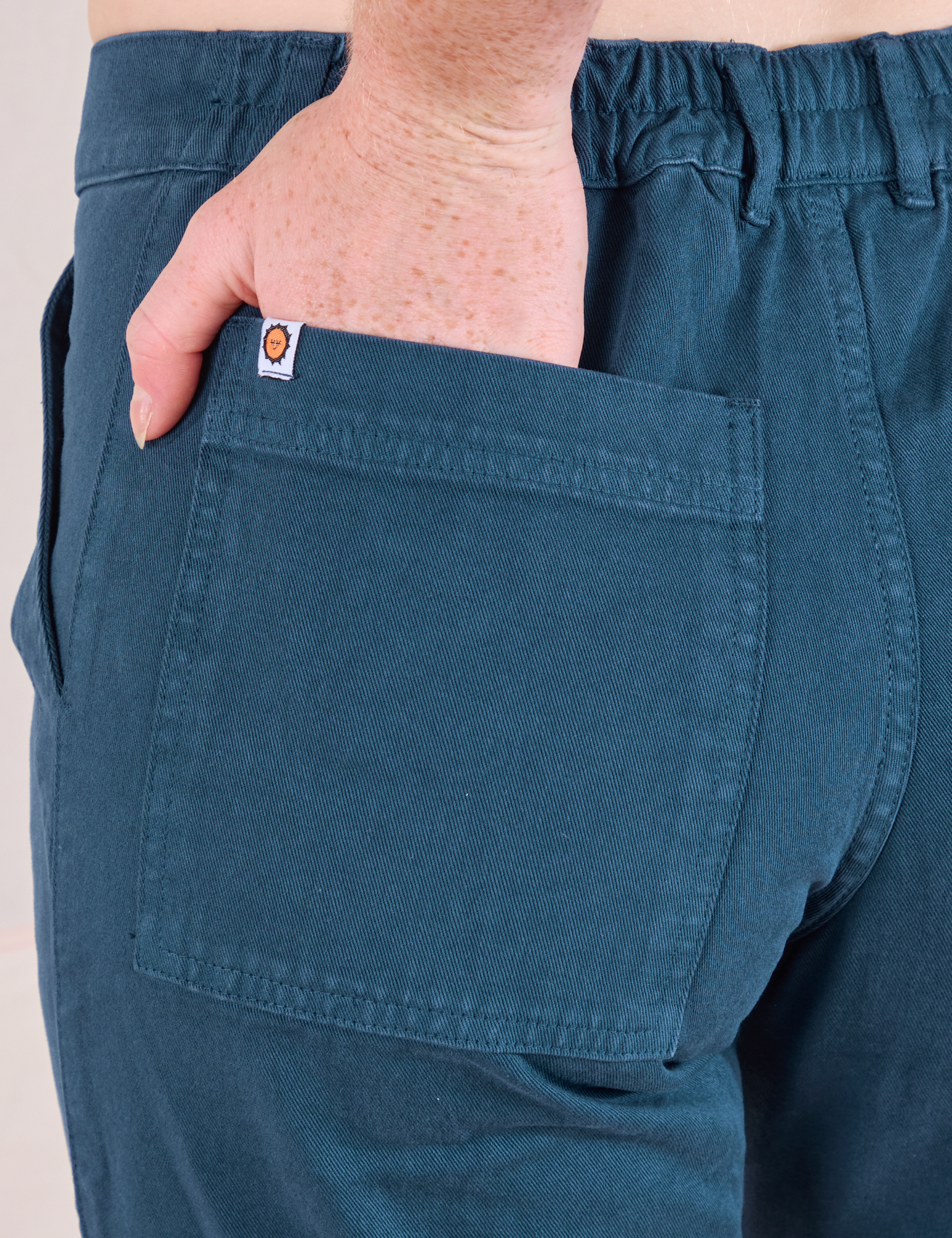 Mid-Rise Work Pants in Lagoon close up of Margaret's hand in the back pocket