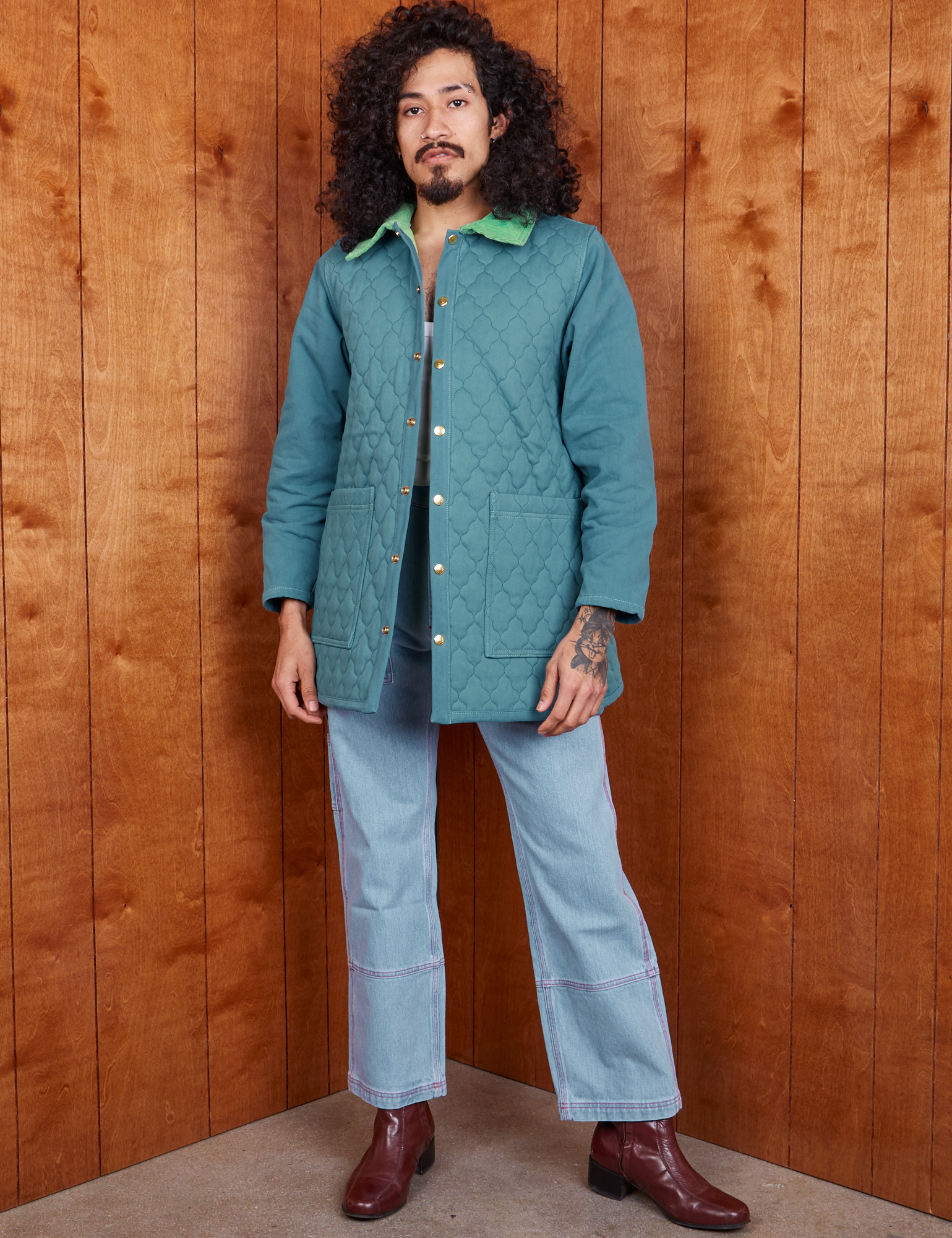 Jesse is wearing Quilted Overcoat in Marine Blue and light wash Carpenter Jeans