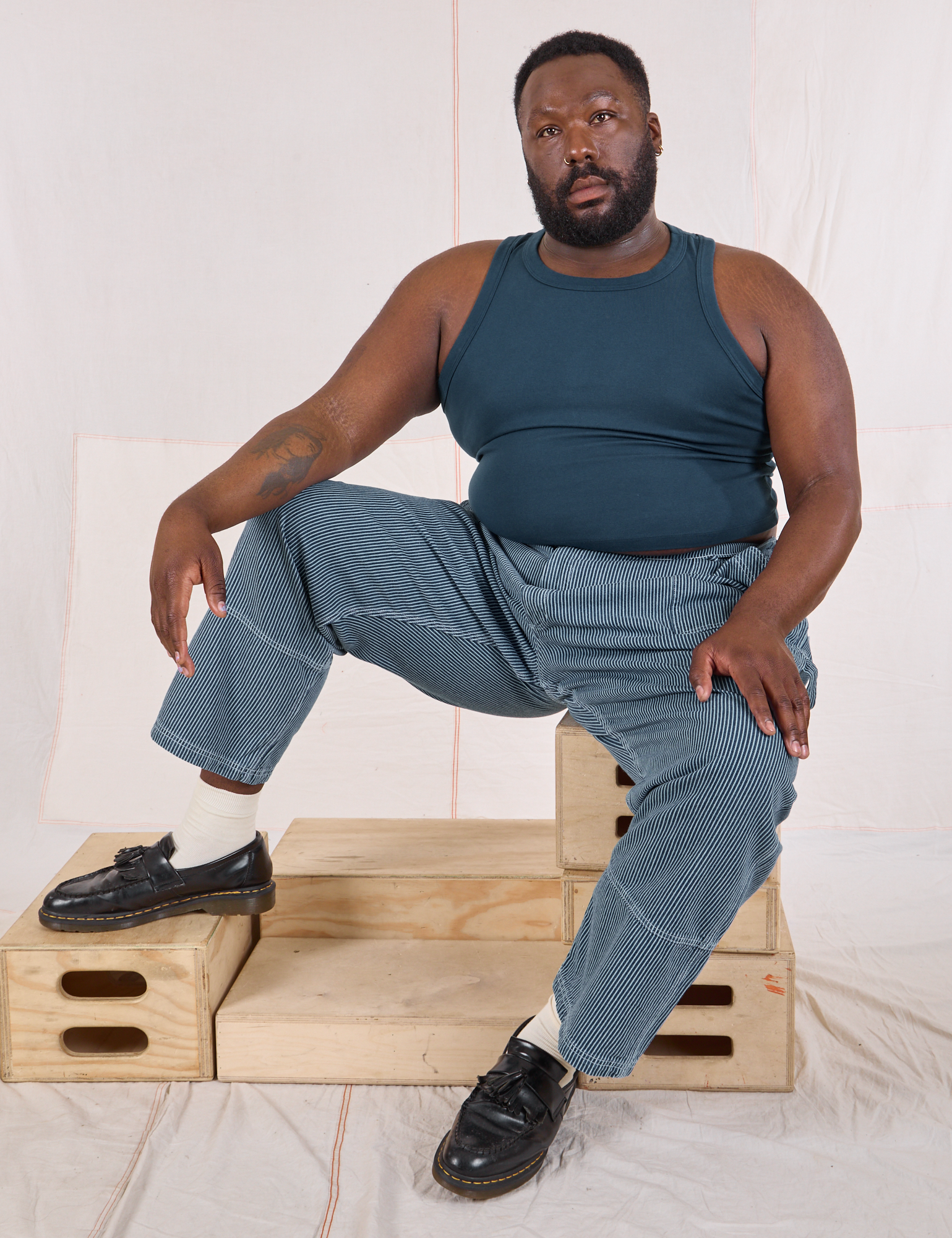 Elijah is wearing Railroad Carpenter Jeans in Baby Blue and marine blue Muscle Tee