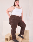 Angled front view of Railroad Carpenter Jeans in Fudgesicle Brown and vintage tee off-white Square Neck Tank on Marielena