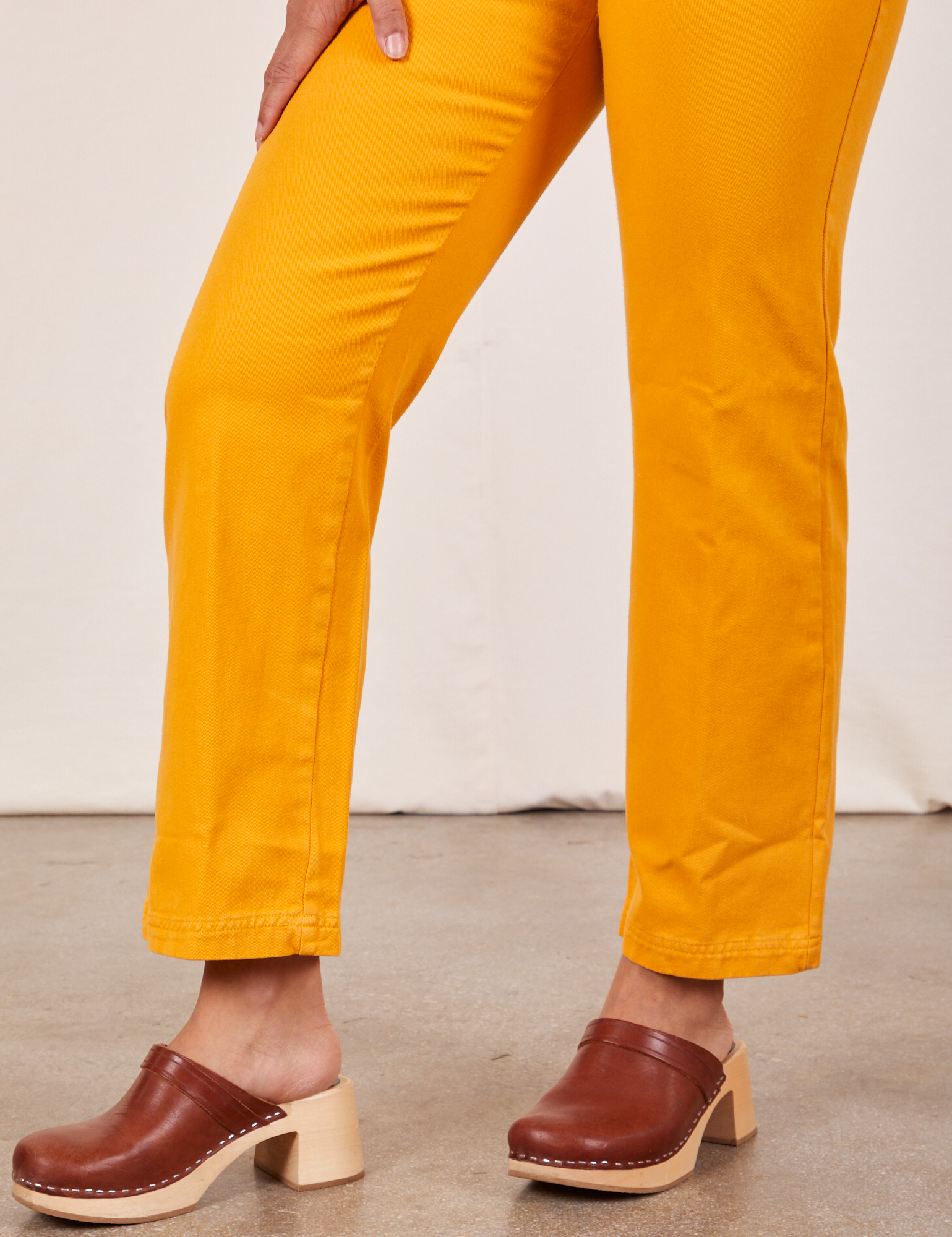 Side view pant leg close up of Short Sleeve Jumpsuit in Mustard Yellow worn by Gabi
