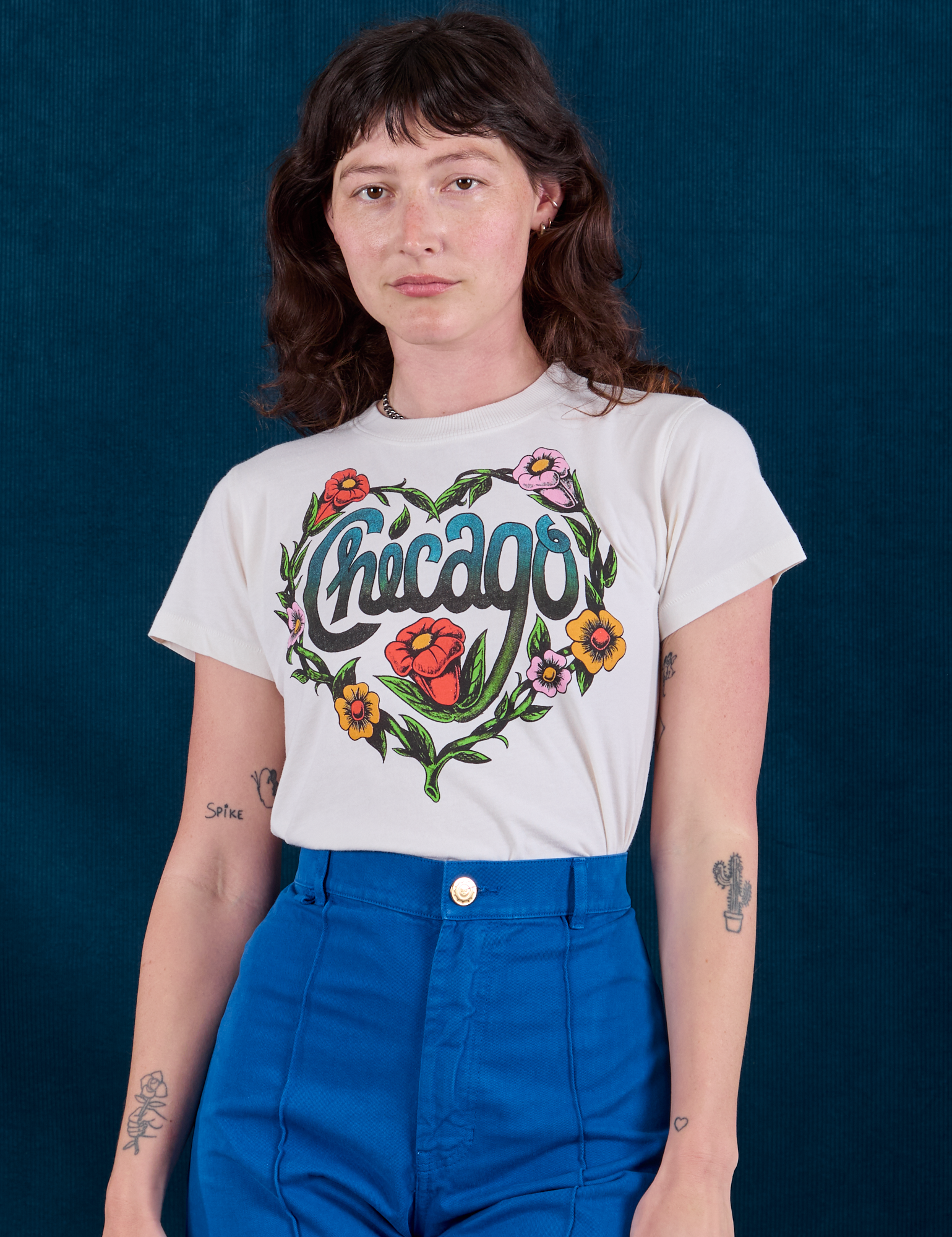 Alex is wearing Chicago Tourist Tee tucked into royal blue Western Pants