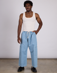 Isaac is wearing The Tank Top in Vintage Tee Off-White and light wash denim drop pocket pants