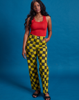 Kandia is 5'3" and wearing XS Checkerboard Work Pants in Yellow/Black paired with mustang red Tank Top