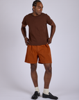Jerrod is 6’3” and wearing M Pleated Trouser Shorts in Burnt Terracotta paired with fudgesicle brown Organic Vintage Tee