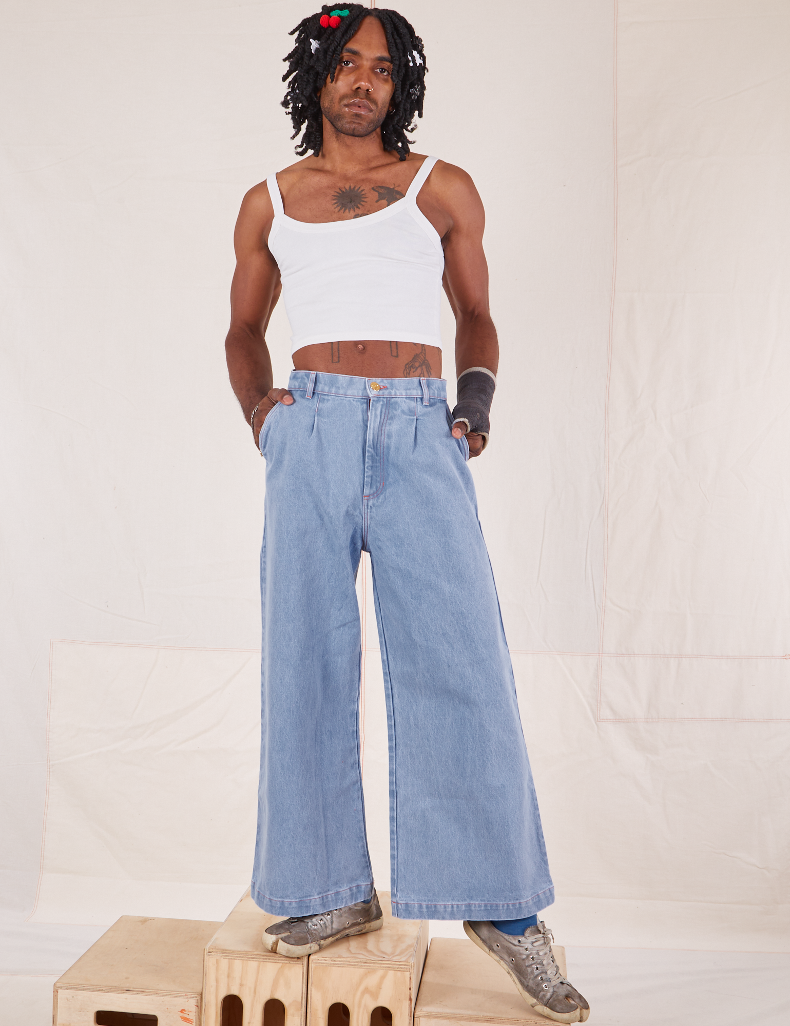 Jerrod is wearing Indigo Wide Leg Trousers in Light Wash and vintage off-white Cami