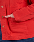 Close up of Juliet's hand in the front pocket of Denim Work Jacket in Mustang Red