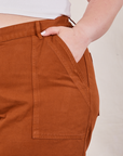 Classic Work Shorts in Burnt Terracotta front pocket close up. Ashley has her hand in the pocket.