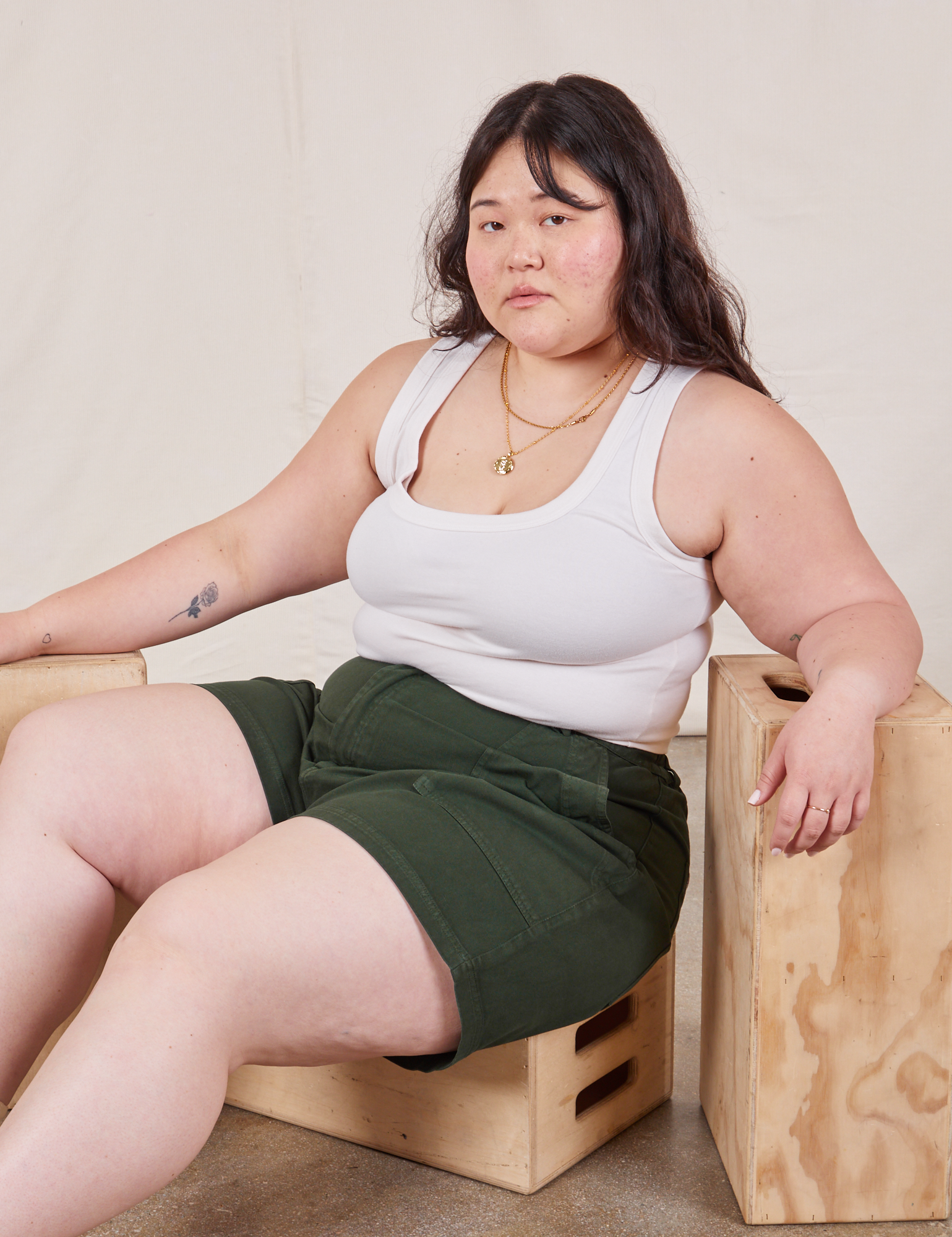Ashley is wearing Classic Work Shorts in Swamp Green and a Cropped Tank Top in vintage tee off-white