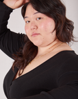 Ashley is wearing Wrap Top in Basic Black