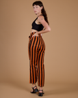 Angled back view of Black Stripe Work Pants in Construction Orange on Alex